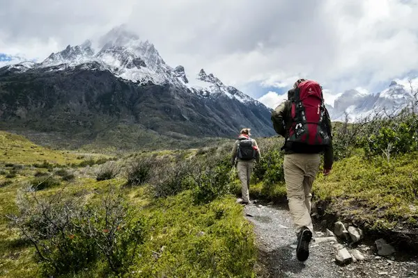 Two people walking together along a mountain trail
